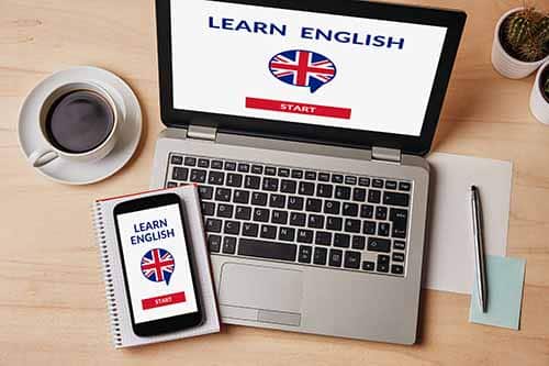 טלפון ומחשב עם סמלים של אנגלית בתוכם - לימוד אנגלית מרחוק